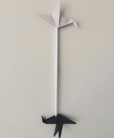 Two identical paper cranes with one that is white and one that is black